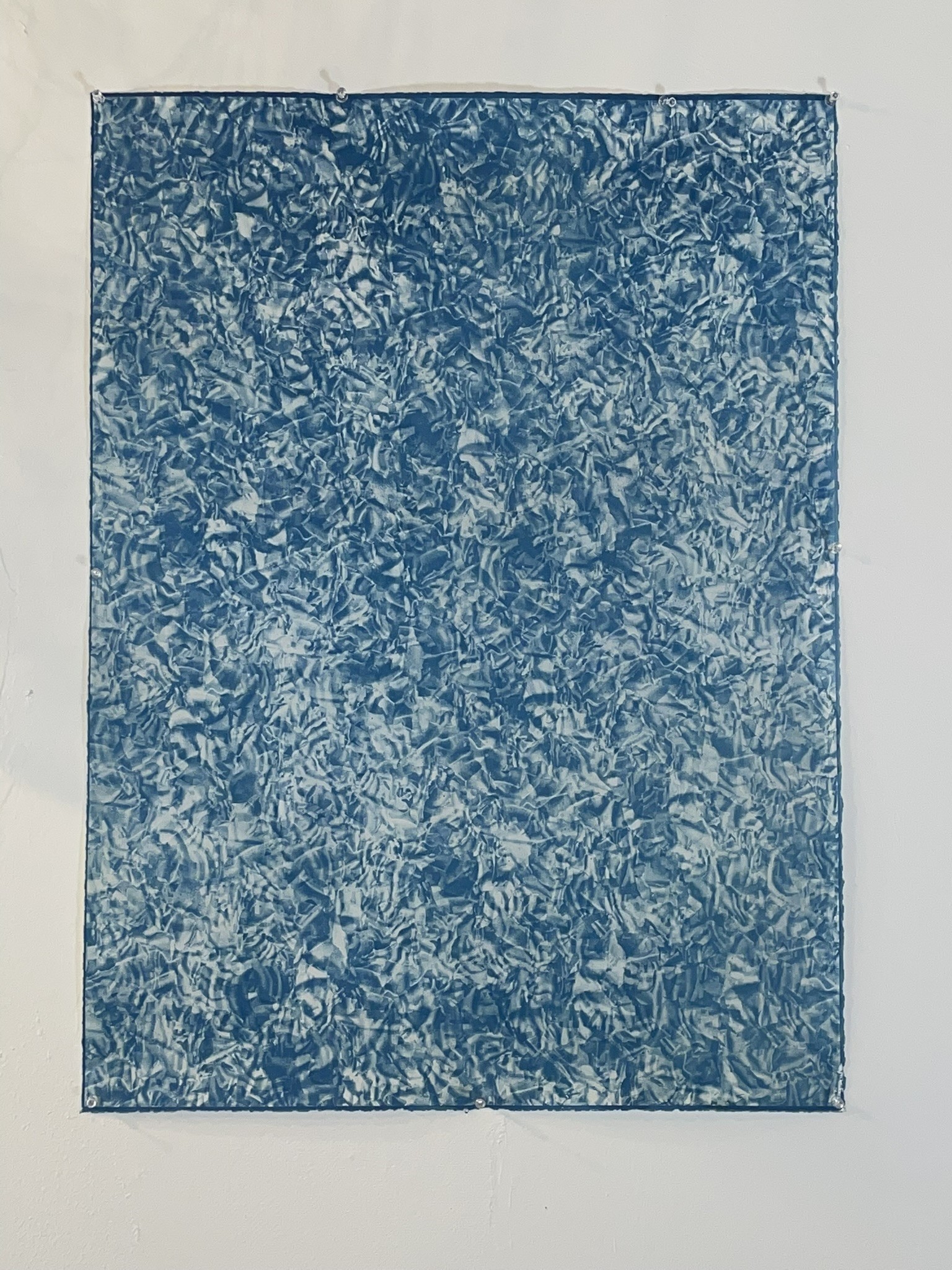 A large cyanotype of what looks like waves in a pool.